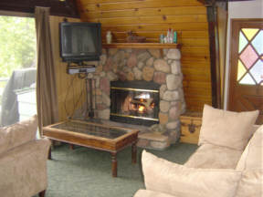 Cozy Living Room with rock fireplace in thewoods cabin near National Forest.